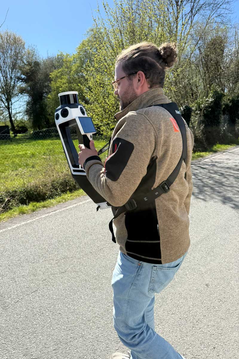 Vermessungstechniker erfasst eine Straße mit einem tragbaren mobilen 3D-Laserscanner.